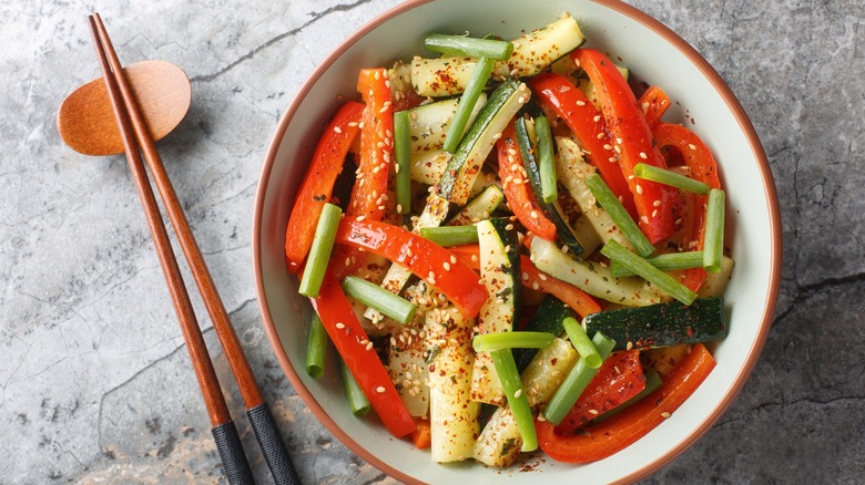 Vegetable stir-fry in a bowl with zucchini, bell peppers, and green onions