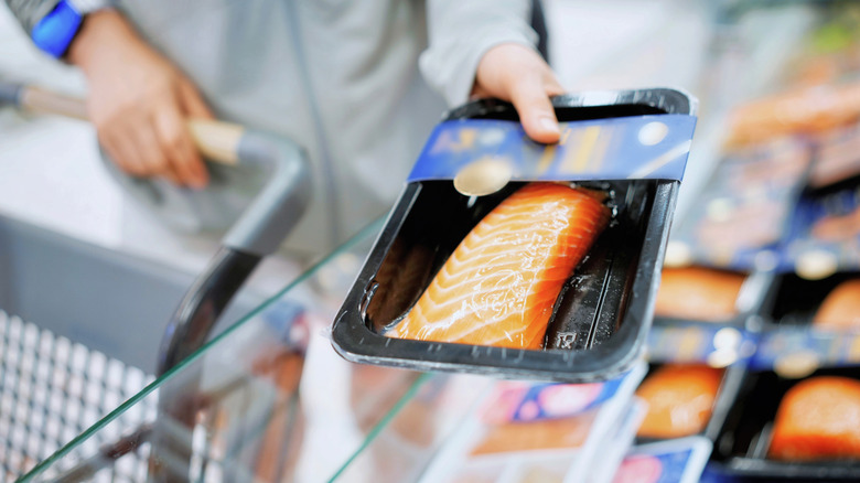 A woman shopping for fish at the grocery store