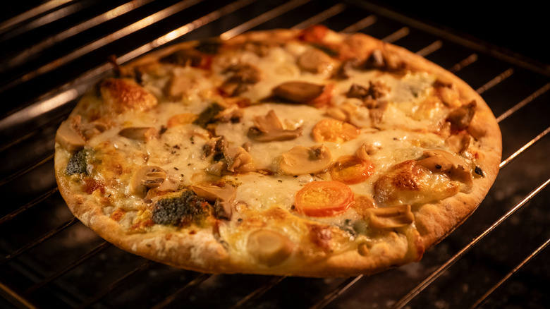 frozen pizza cooking on oven rack