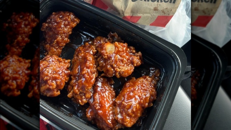 KFC Honey BBQ Wings in a black tray held up to the camera