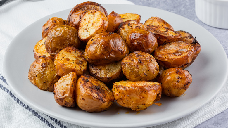 Golden brown roasted potatoes on a white plate