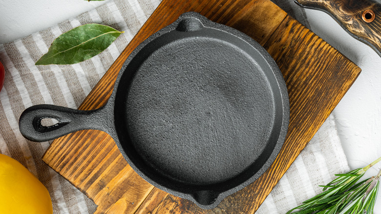 A cast-iron skillet is photographed from above on a cutting board.