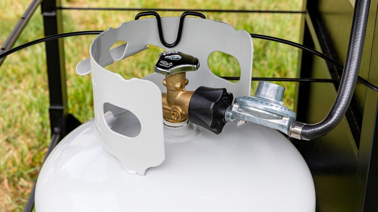 Close-up of a white propane tank in a backyard