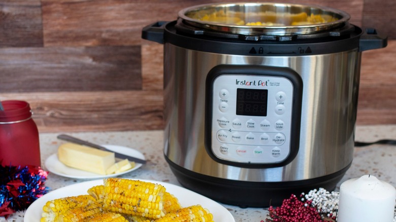 Instant Pot next to a plate of corn on the cob