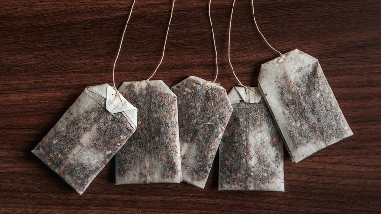 Several tea bags spread across a walnut-colored table.