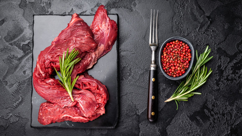 Raw skirt steak is arranged on a tray and seen from above.