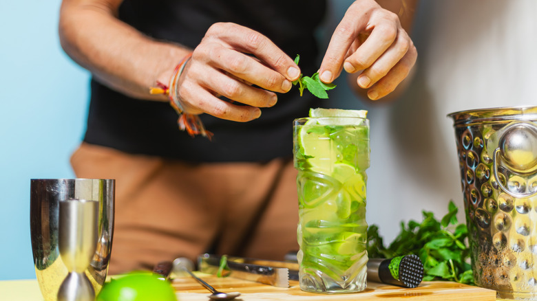 Bartender garnishes a mojito