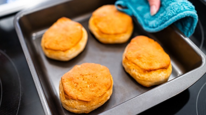 Pulling biscuits from oven