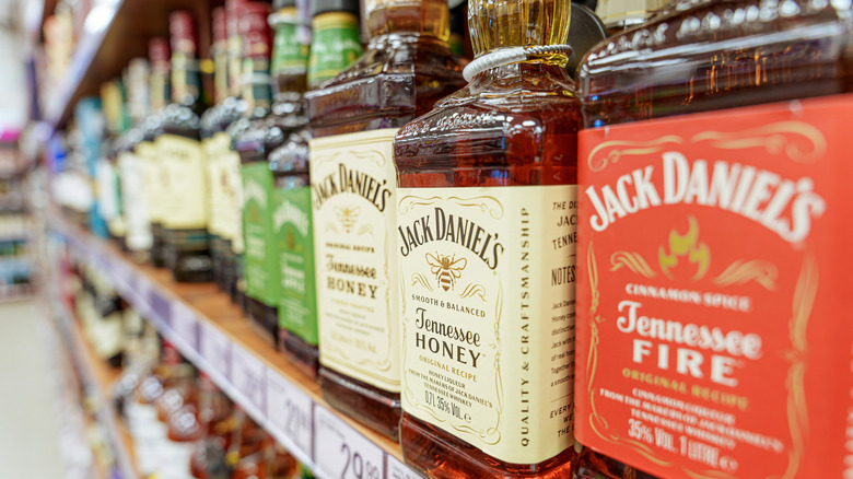 An array of Jack Daniel's bottles on a supermarket shelf.