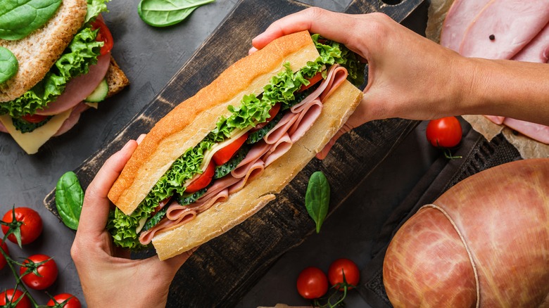 Hands holding giant sanwich 