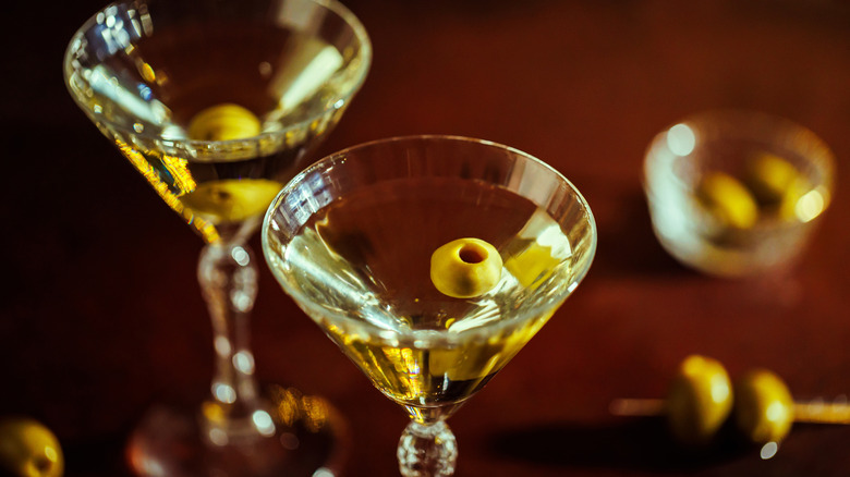 Two martinis with olives in crystal glasses