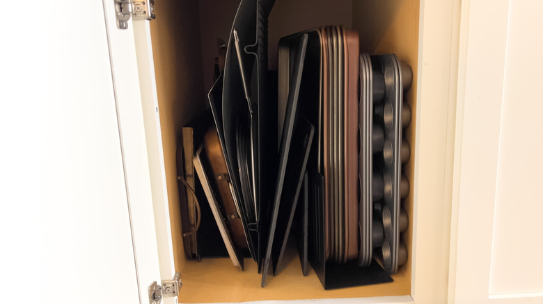 kitchen cabinet with various baking pans