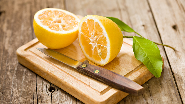 Meyer lemon cut in half on cutting board