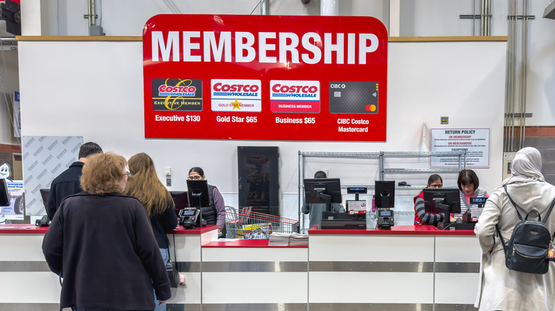 A Costco membership counter where customers are being assisted by employees
