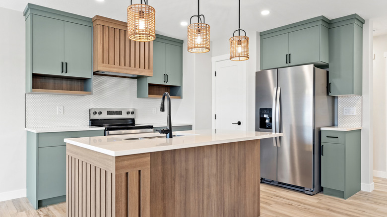 kitchen with sage green cabinets and white walls