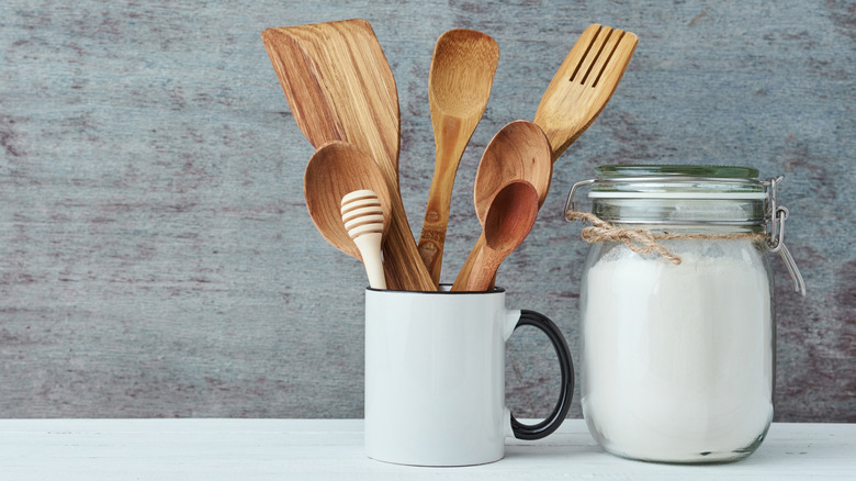 ceramic mug full of wooden kitchen utensils