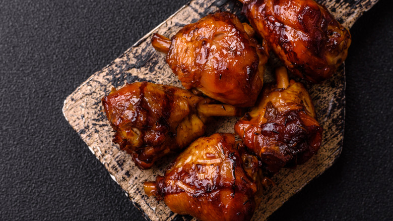 BBQ chicken thighs on a wooden cutting board