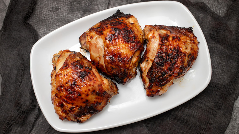 BBQ chicken thighs on a white plate