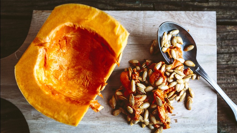 Pumpkin seeds scooped from pumpkin on wooden table.