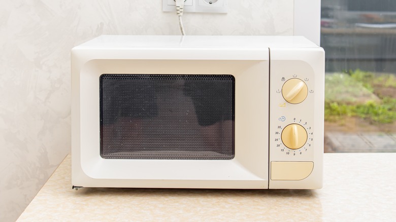 Old microwave on countertop
