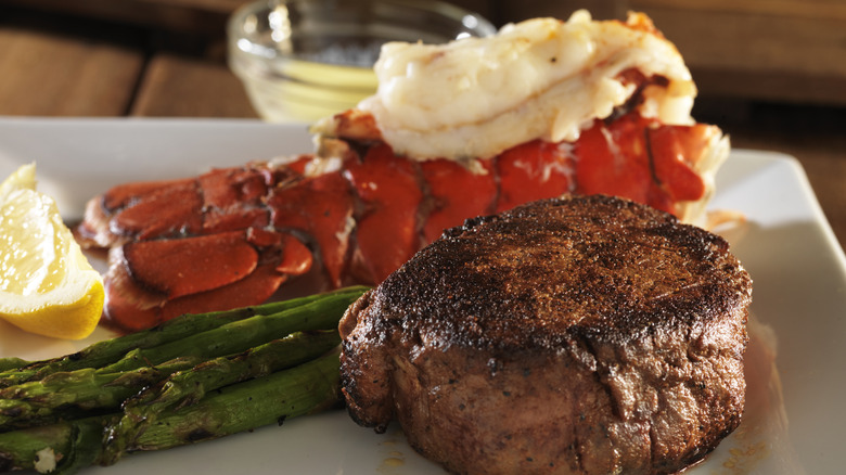 Steak and lobster special with asparagus on a white plate