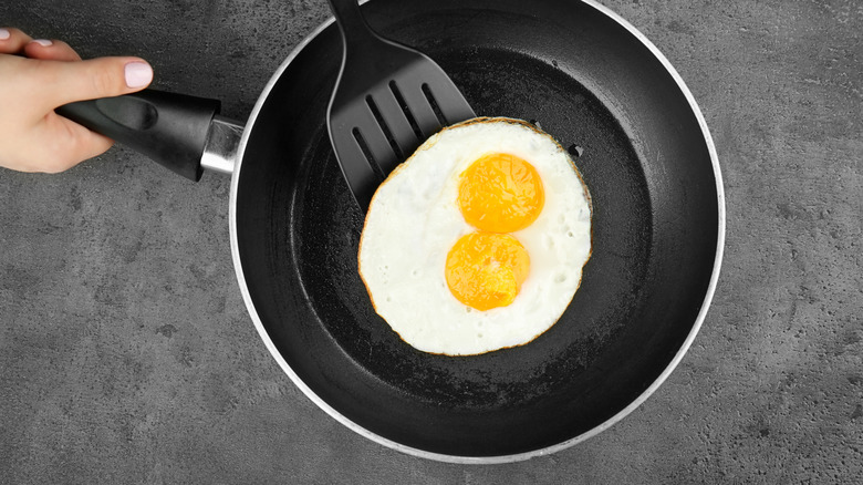Over-easy eggs being flipped in pan