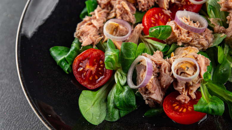 A tuna salad with onion and tomato.