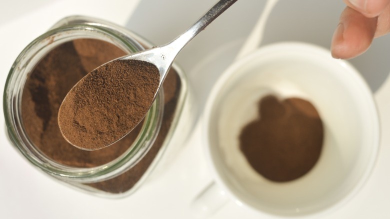 Espresso powder being scooped out of container