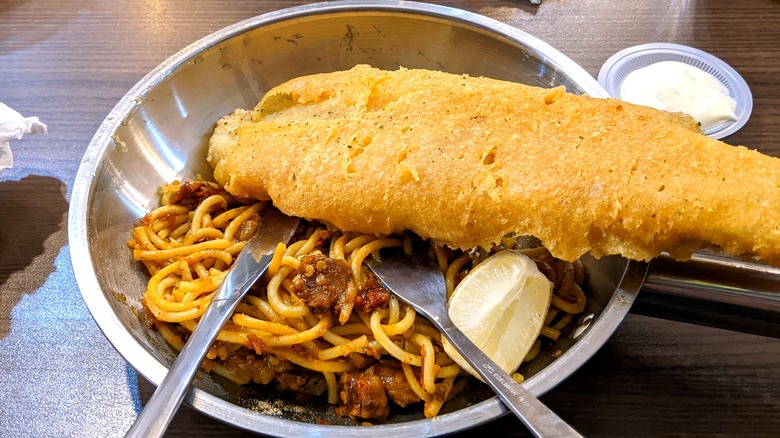 Battered fish on spaghetti with red sauce