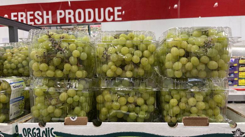 A Costco display with packages of green grapes