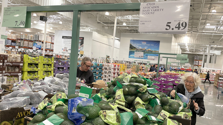 Customers shopping for bagged avocados at Costco.