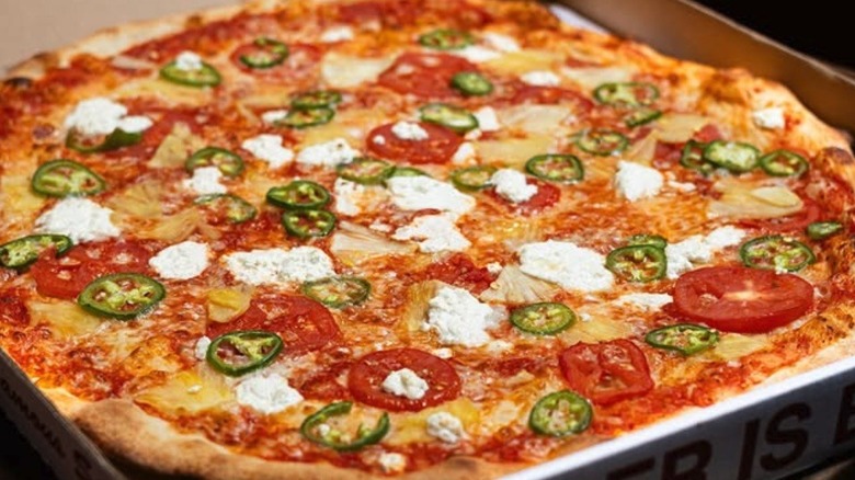A pizza with jalapenos, tomato, pineapple and feta at Big Mario's Pizza in Seattle.