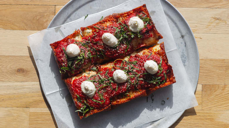 A Detroit-style pizza on a plate at a restaurant