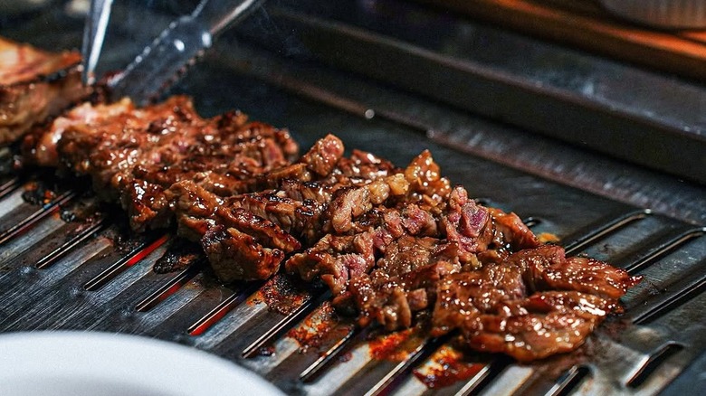 Marinated galbi cooking over a grill