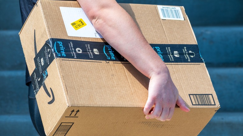Person carrying an Amazon box.