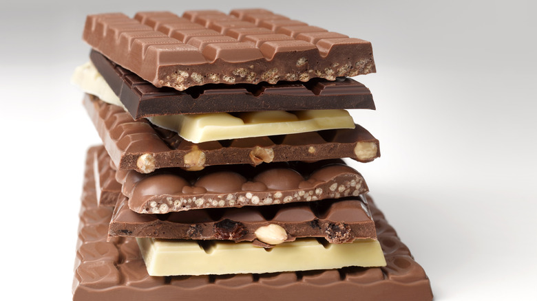Bars of alternating milk, white, and dark chocolate stacked on top of one another.