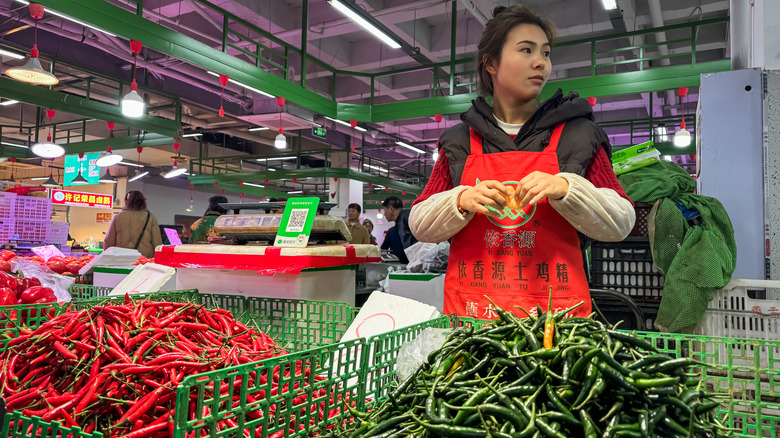 Woman selling red and green peppers