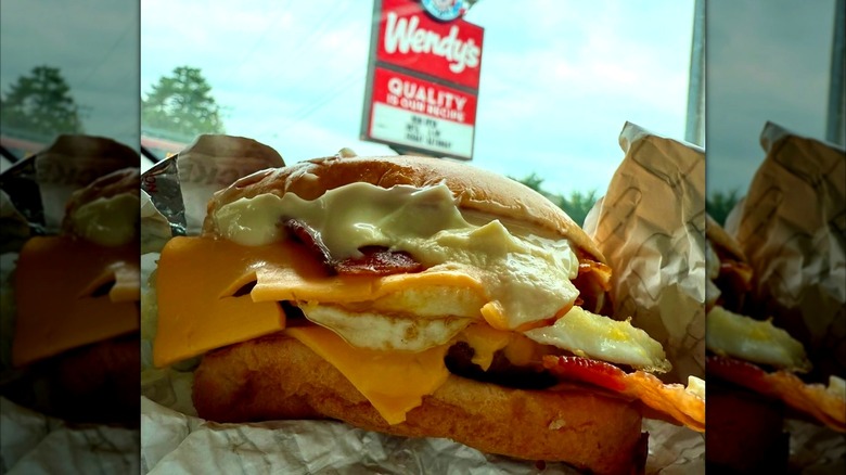 Wendy's Breakfast Baconator with a Wendy's sign in the background