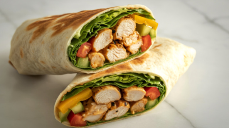 A grilled chicken wrap sliced in half