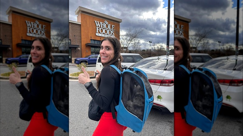Person carrying dog in backpack