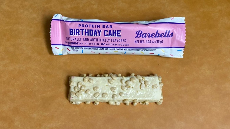 a Birthday Cake Barebells protein bar beside its packaging