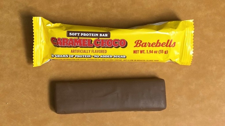 a Caramel Choco Barebells protein bar beside its packaging