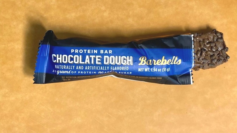 a Chocolate Dough Barebells protein bar peeking out of its packaging