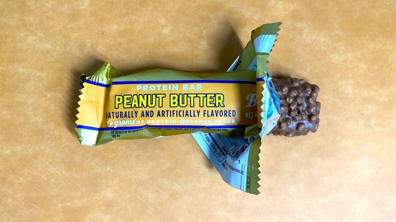 a Peanut Butter Barebells protein bar peeking out of its packaging