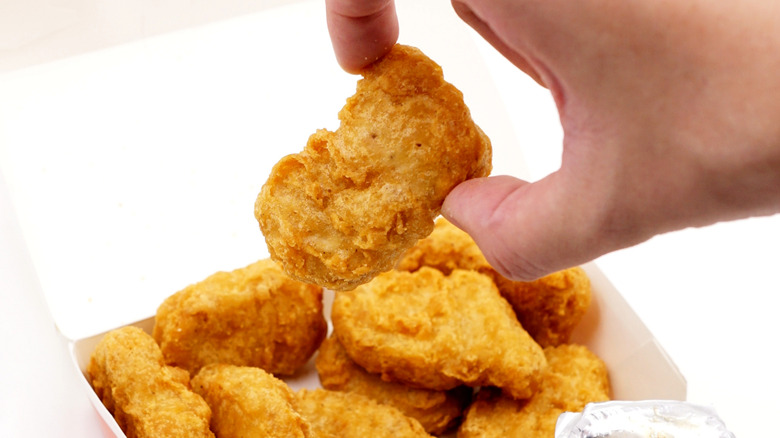 Hand taking Chicken McNugget from box