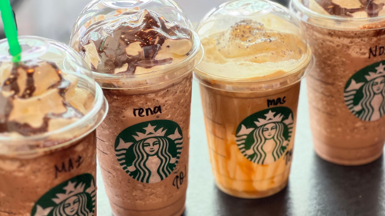 Four Starbucks drinks lined up on a counter
