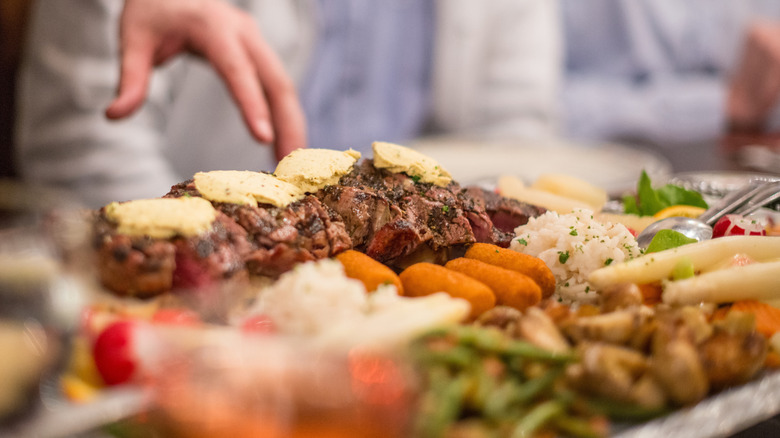 Grilled steaks served with vegetables in a buffet style setting