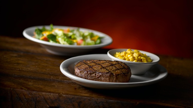 A sirloin dinner with corn and a salad from Texas Roadhouse