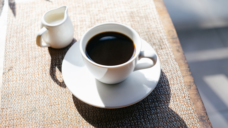 Black coffee and milk on table