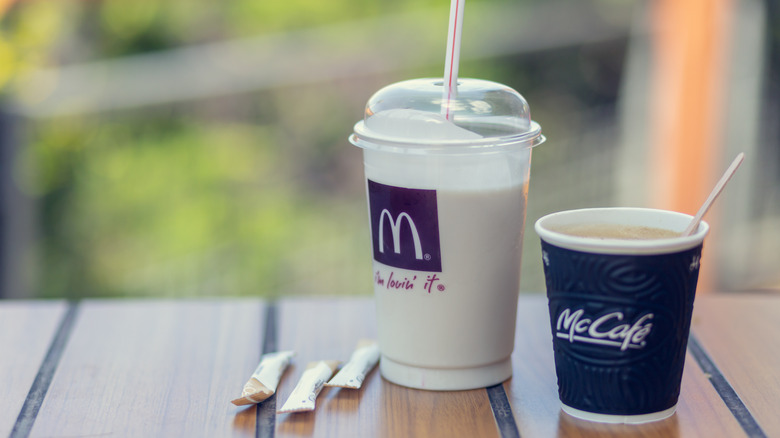 McCafe coffee and milkshake rest on a table